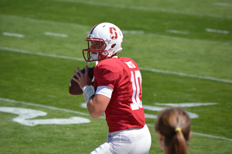 the young man is holding the football on the field