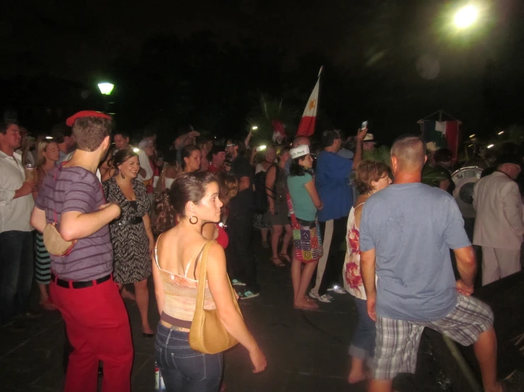 a crowd with flags and people standing around in a park