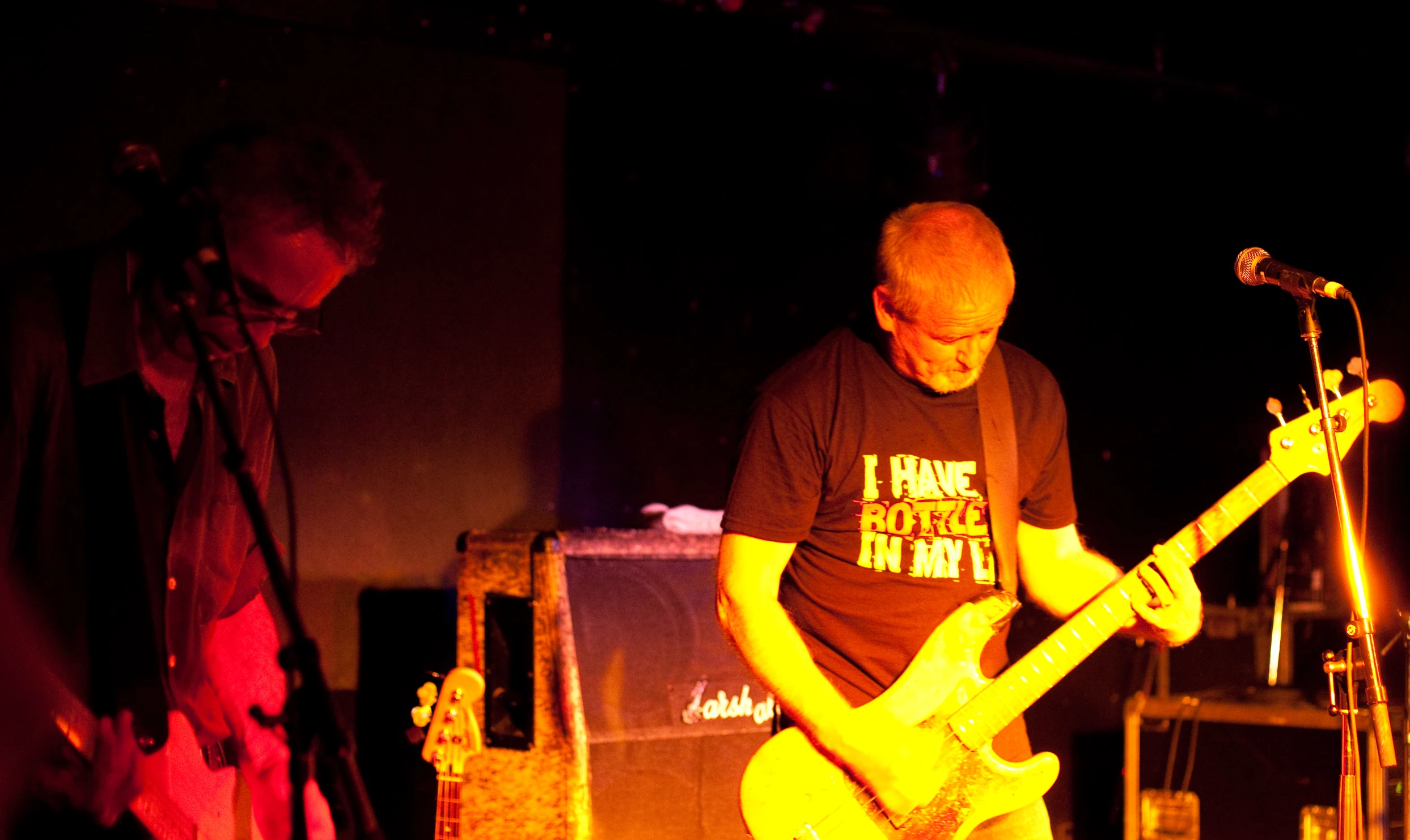 a man standing on top of a stage while playing guitar