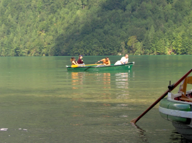 a group of people paddling in small boats on water