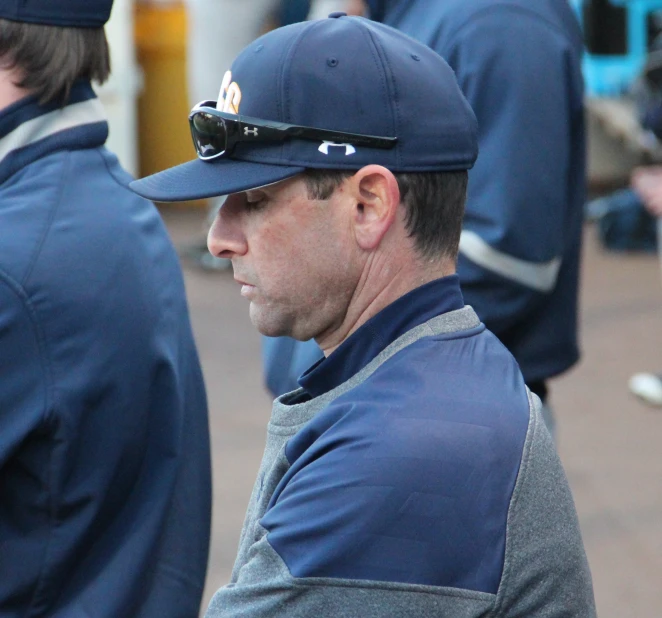 a man in baseball hat and sunglasses looking on