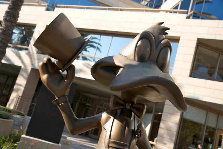statue of goofy holding an empty cup in front of a building