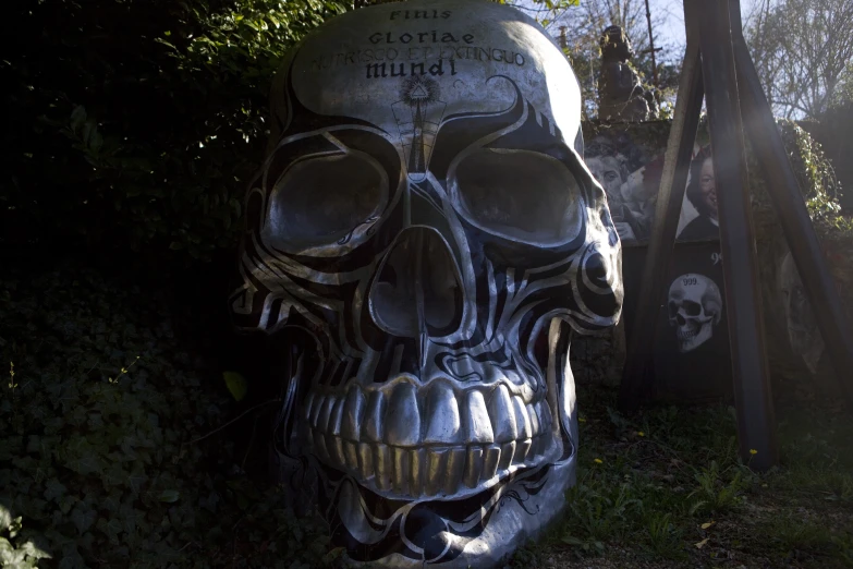 a large silver skull statue sitting next to trees