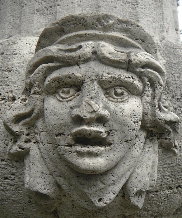 the face of an ancient woman made out of cement
