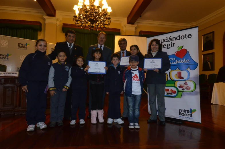 children are posing for the cameras with their award