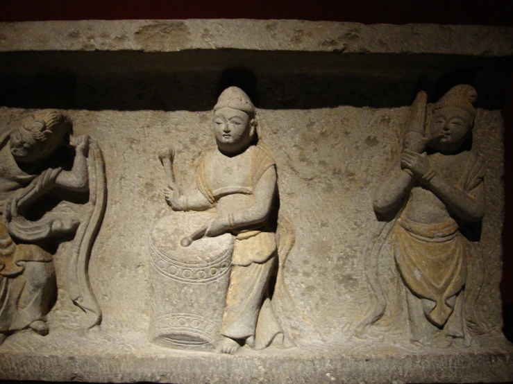 a stone carving of people with buckets