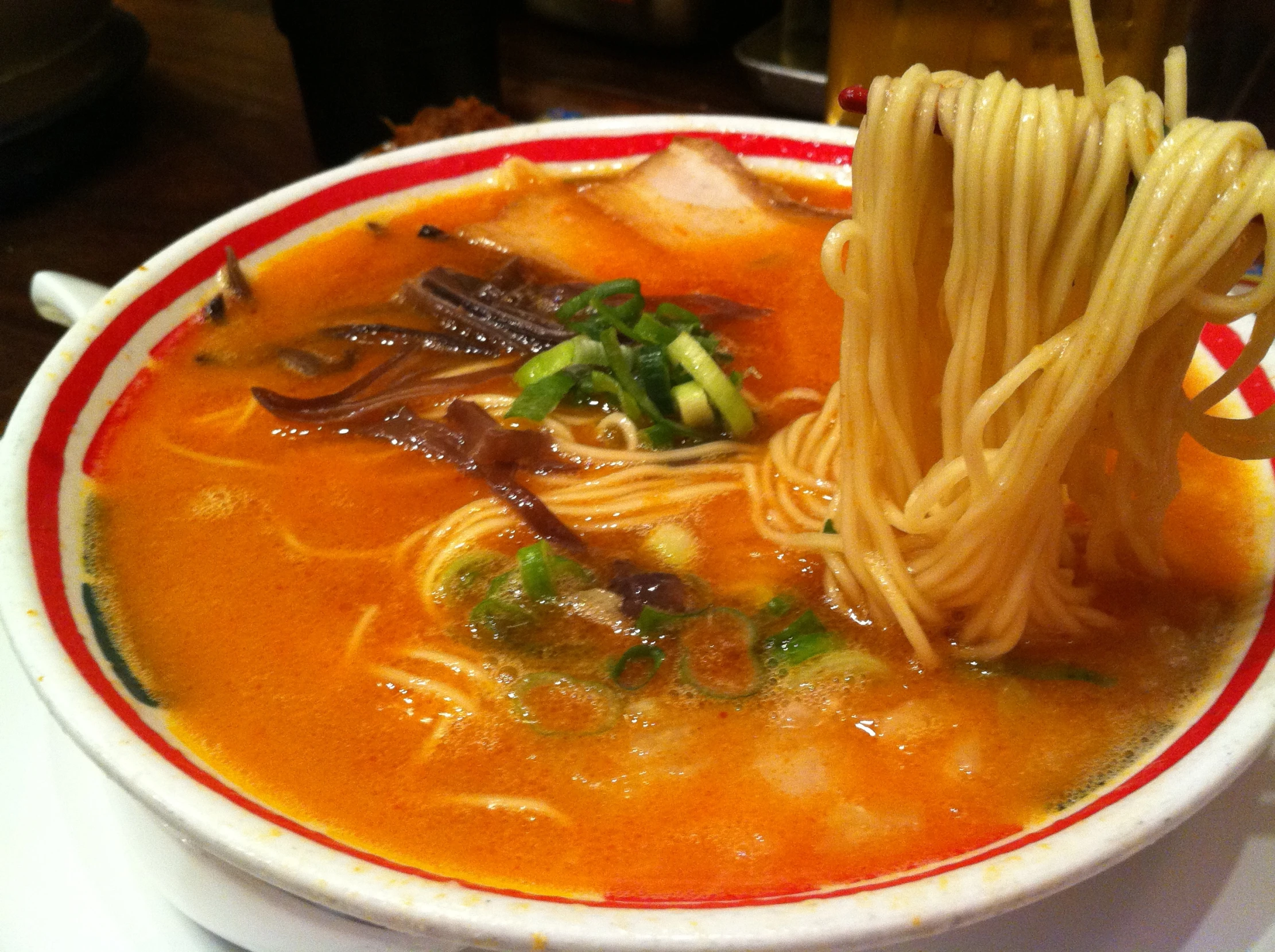 a bowl of soup with a spoon and chopstick