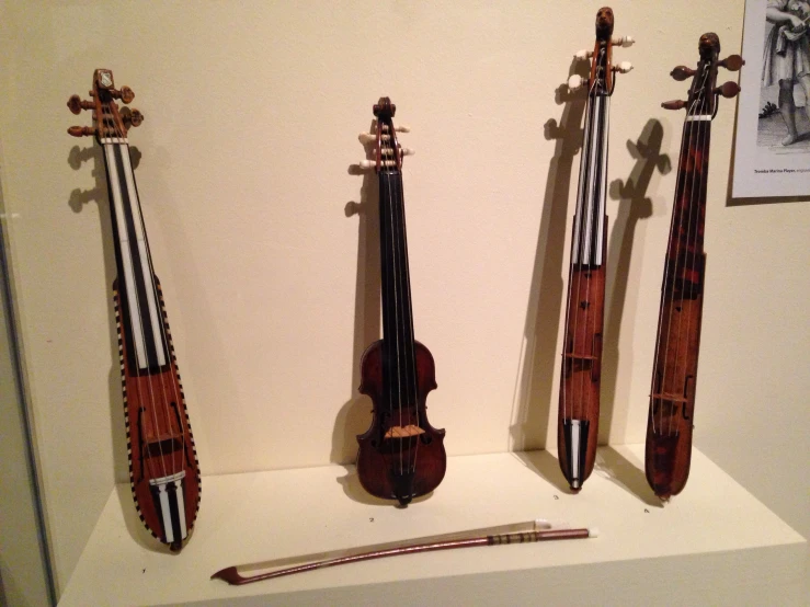 a couple of violin's are displayed on a shelf