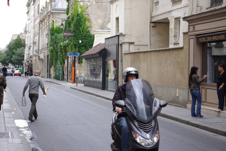 the man is riding his motorcycle down the street