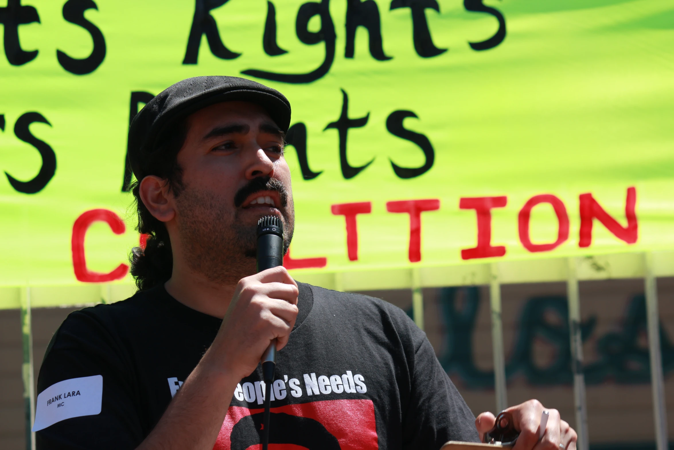 the man is talking on his microphone in front of the banner