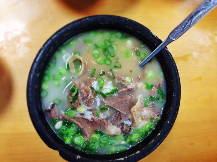 a bowl of soup that is filled with meat and peas