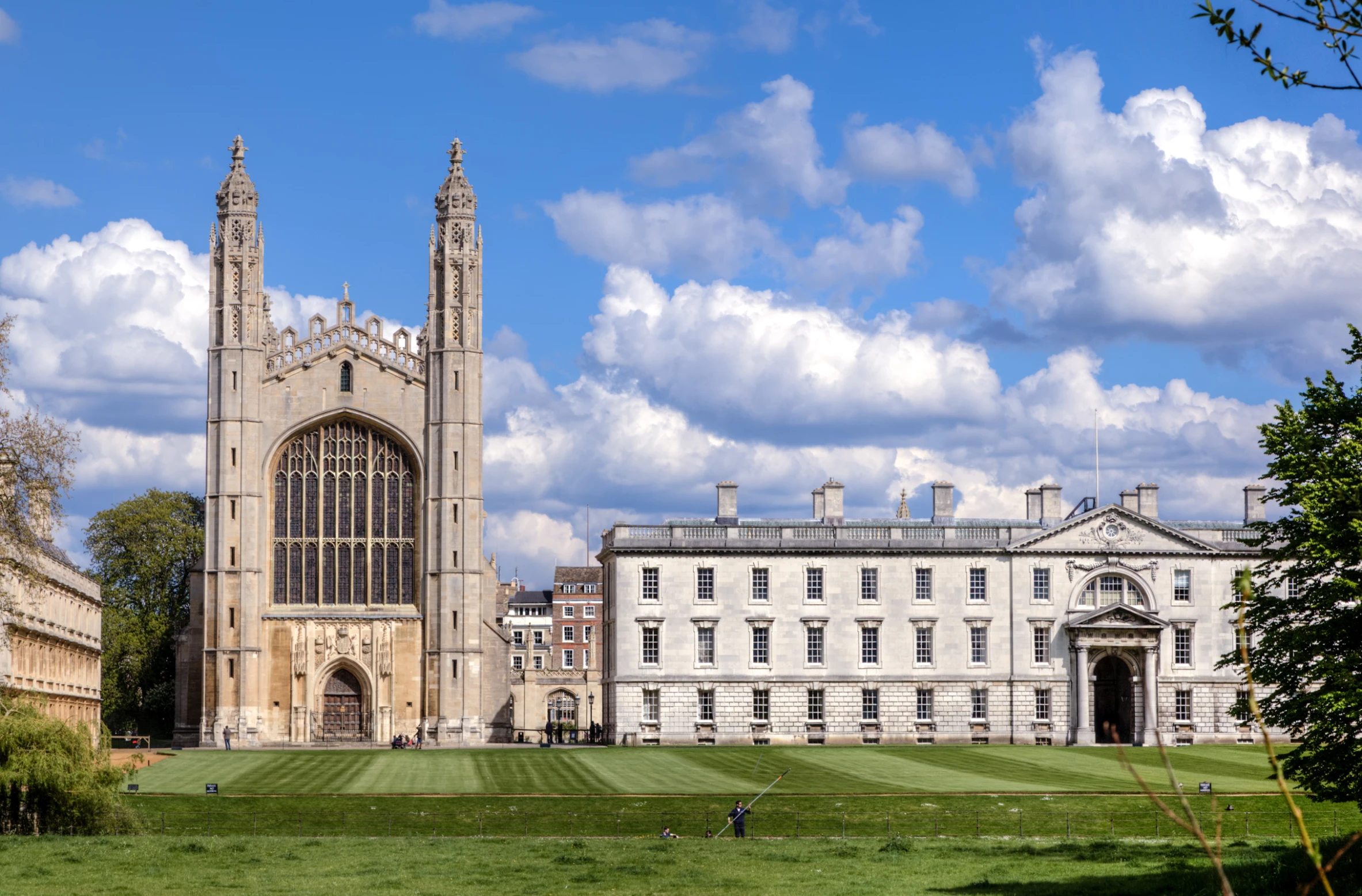 a large building with two towers sitting on a lush green field