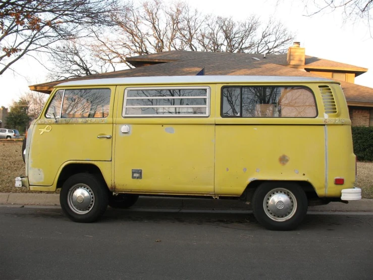 an old yellow van is parked in front of a house