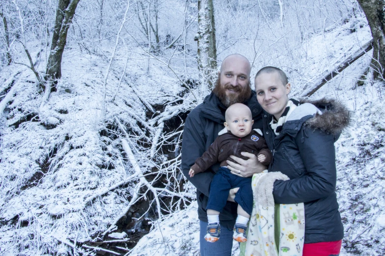 a family stands in front of some snowy trees