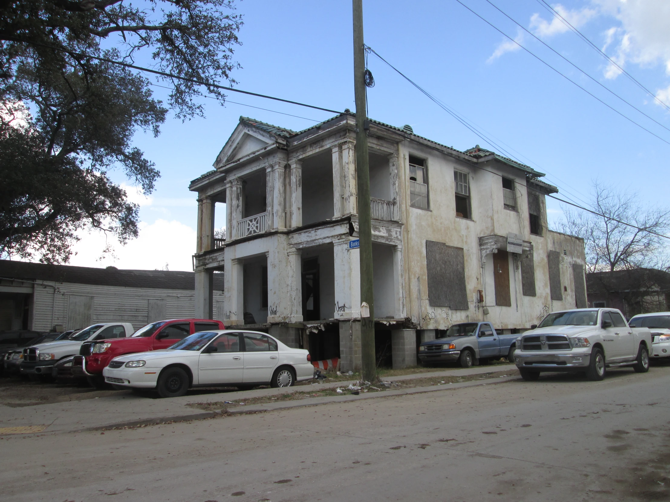 a large white house sitting next to a parking lot