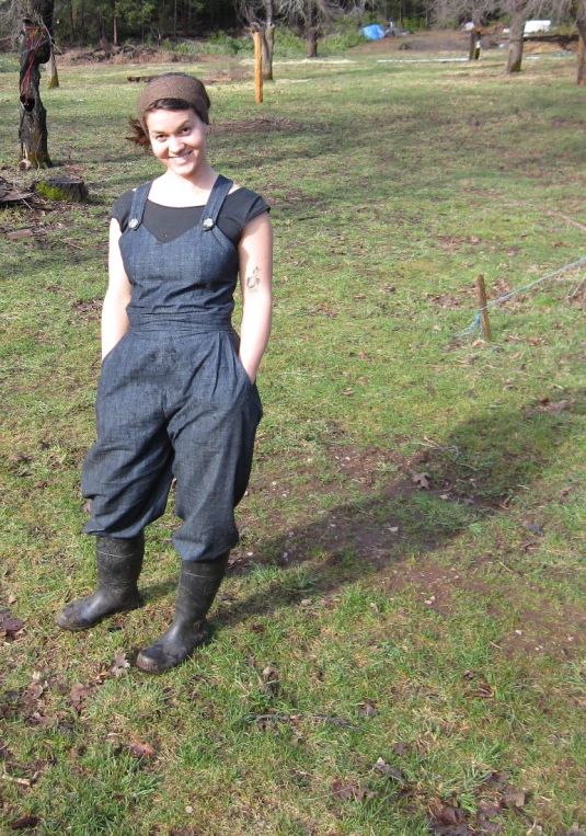 a woman in overalls posing for the camera