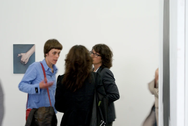 three people standing in a museum looking at a wall