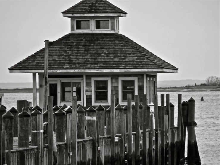 an old, wooden house sits on the edge of a body of water