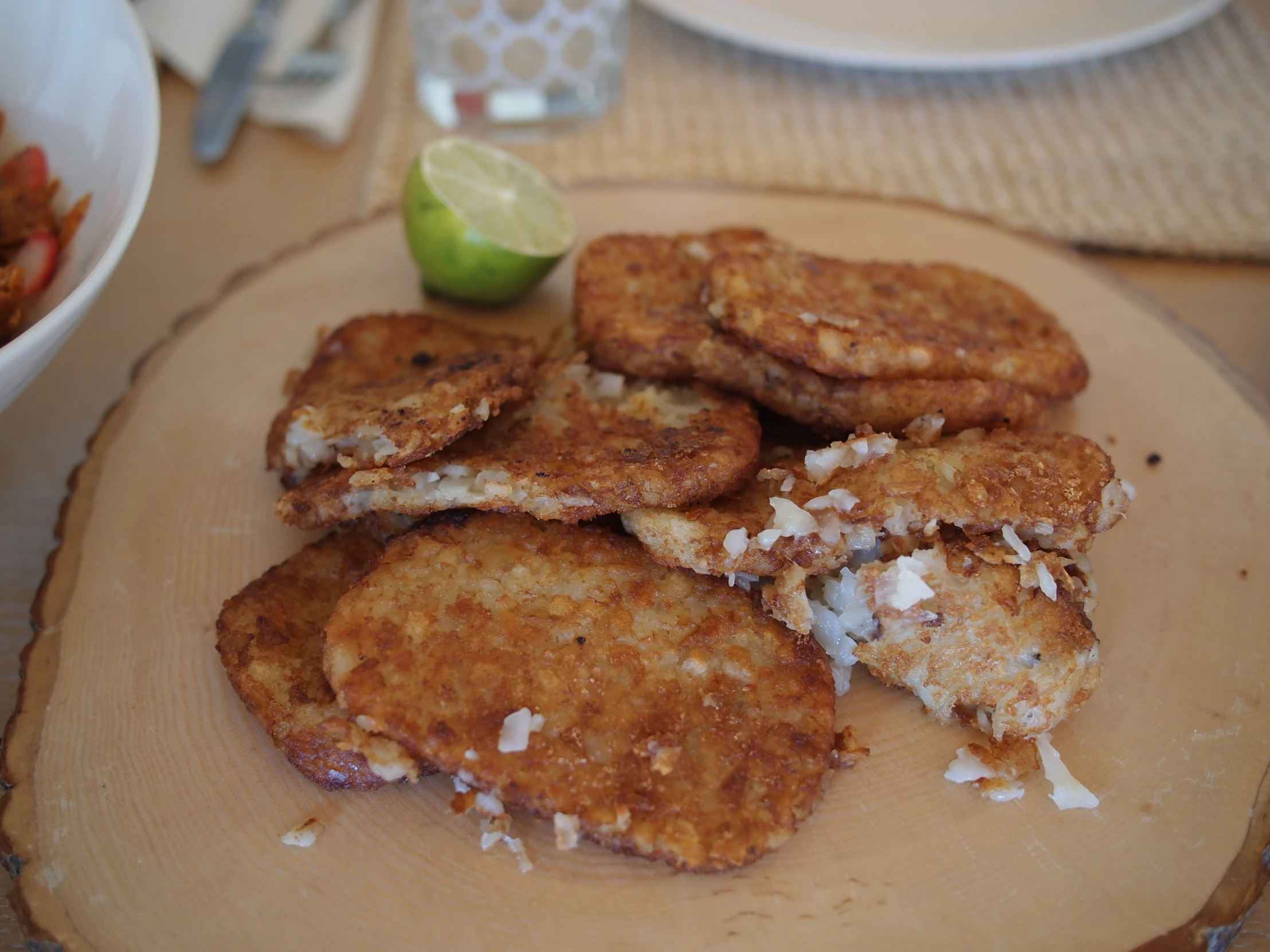 fried crab cakes and some lime next to a bowl