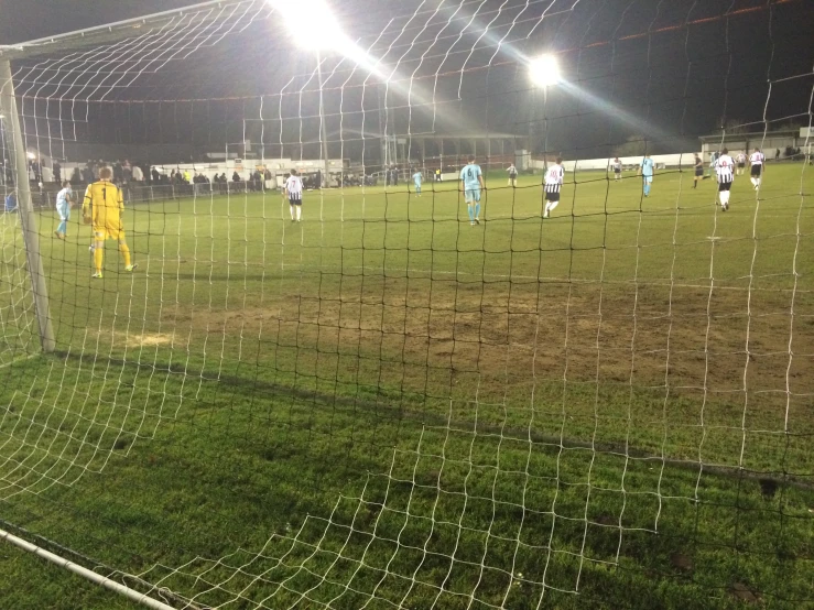 soccer players play on the field at night