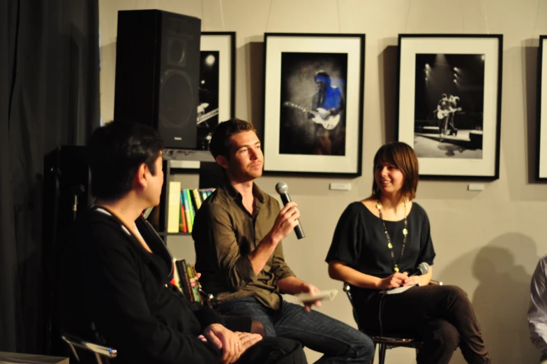 three people are sitting around with microphones