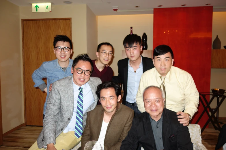 several men posing together for a pograph in an apartment