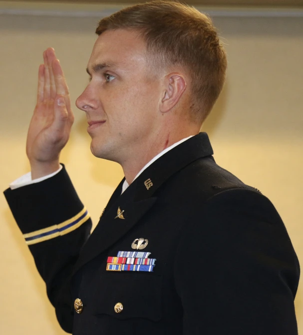 a close up of a man in uniform saluting