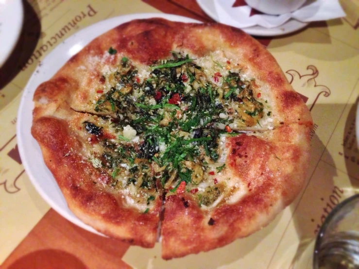 a whole pizza on top of a white plate on a table