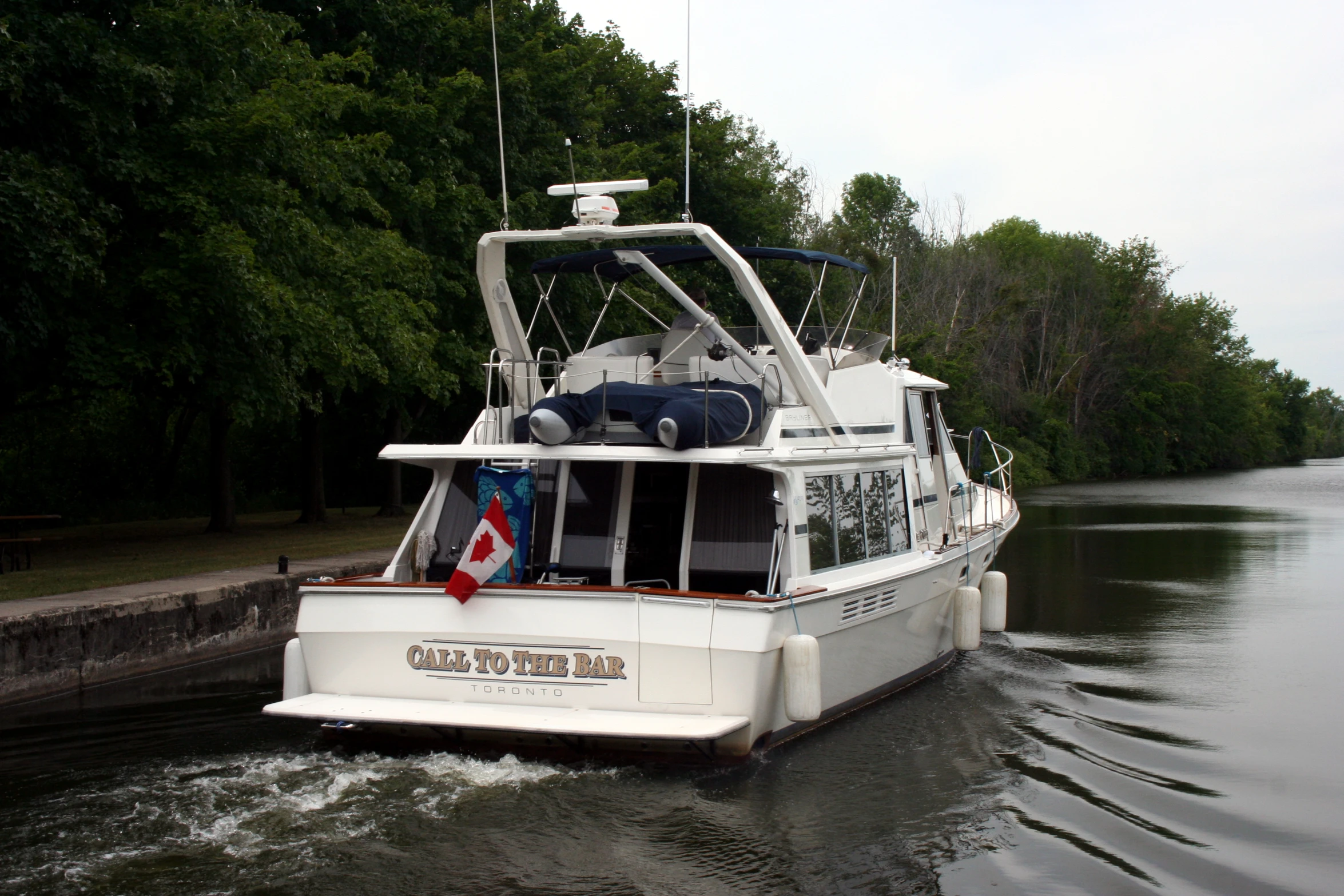 a boat is traveling down a river with trees around it