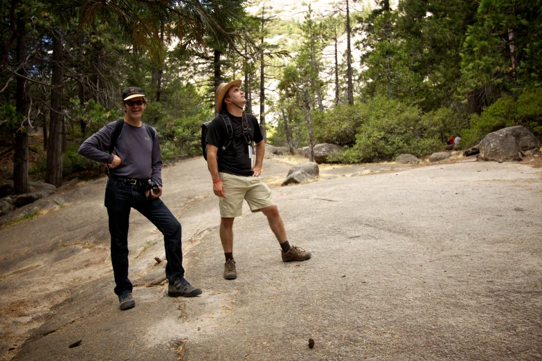 two men in a road with trees in the background