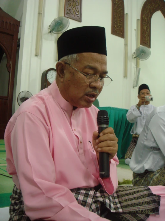 a man sitting in a room next to a microphone