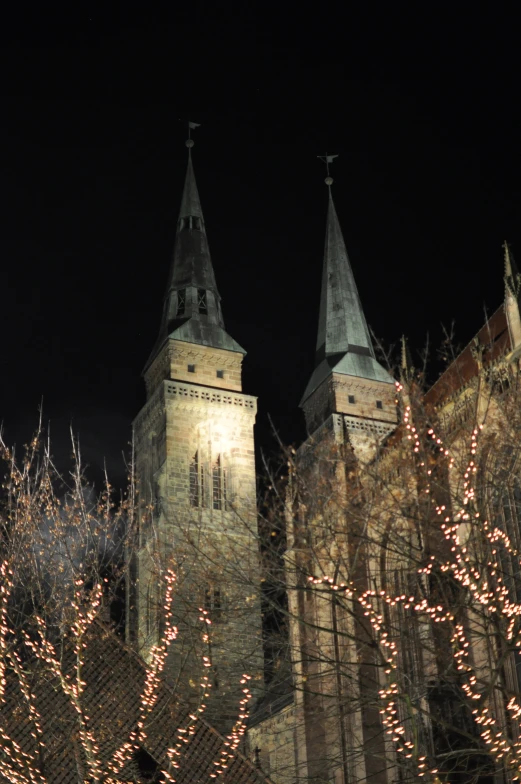 a large cathedral with towers and spires lit up at night