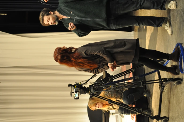 a woman standing by a table holding a cell phone