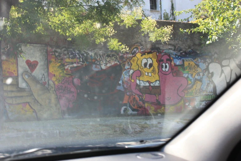 a car that is parked near some graffiti