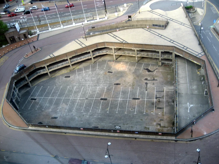 a parking lot inside of a building surrounded by buildings