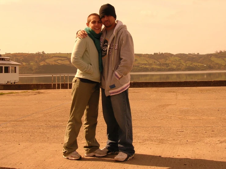 two people are standing together in an empty lot