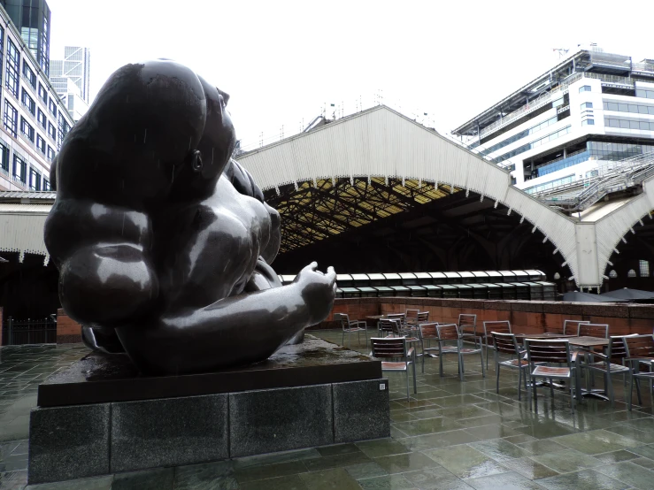 a gray statue in the middle of a courtyard