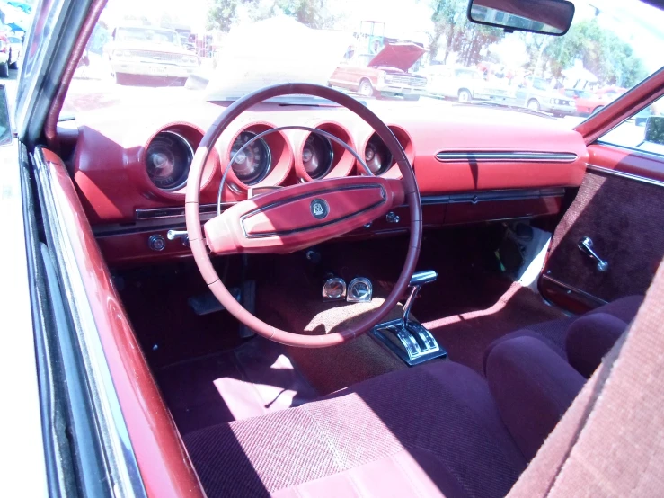 a car dashboard with wood dash boards, blue leather seat covers and two ons and chrome steering wheel