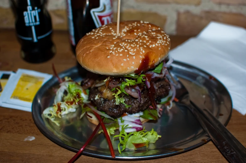 a big burger with toothpicks on a plate