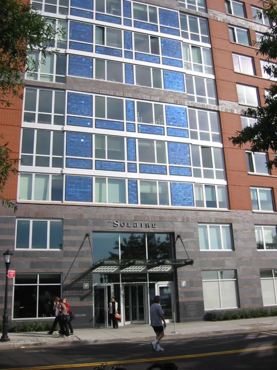 a person walking past a tall building on a city street