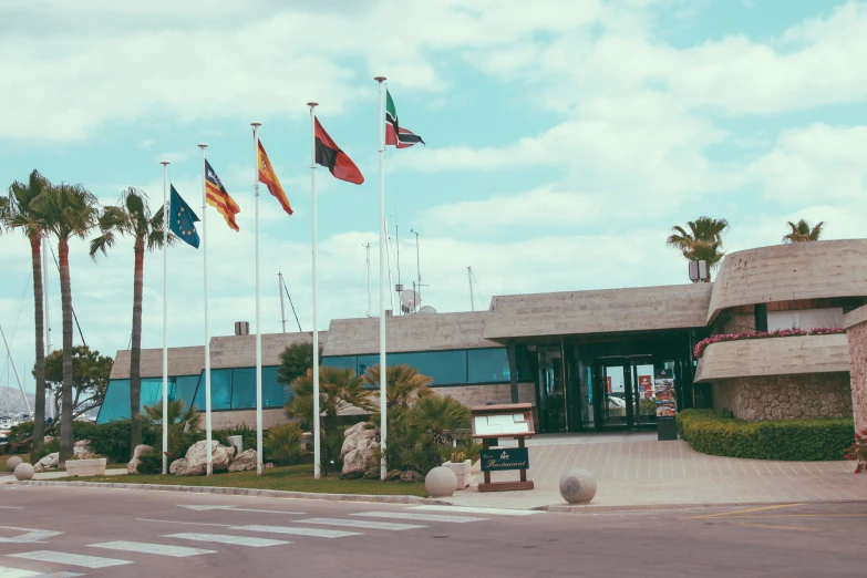 an old building with flags and palm trees