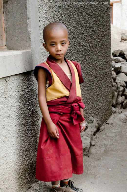 a young african american boy dressed in red and tan clothes