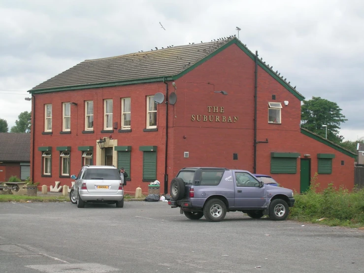 a large red brick building with cars parked in front