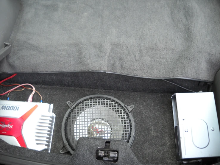 the inside of an open car trunk with electronics