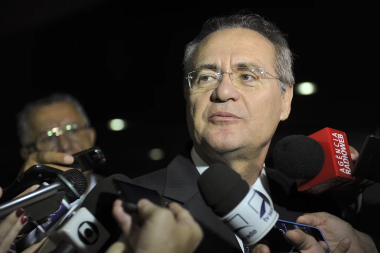 a close up of a man speaking to the media