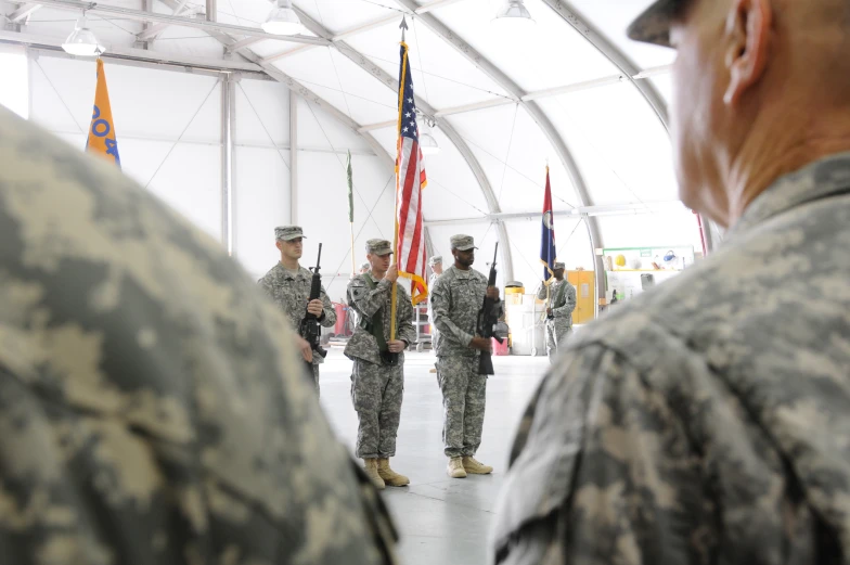 a couple soldiers that are standing in front of a flag