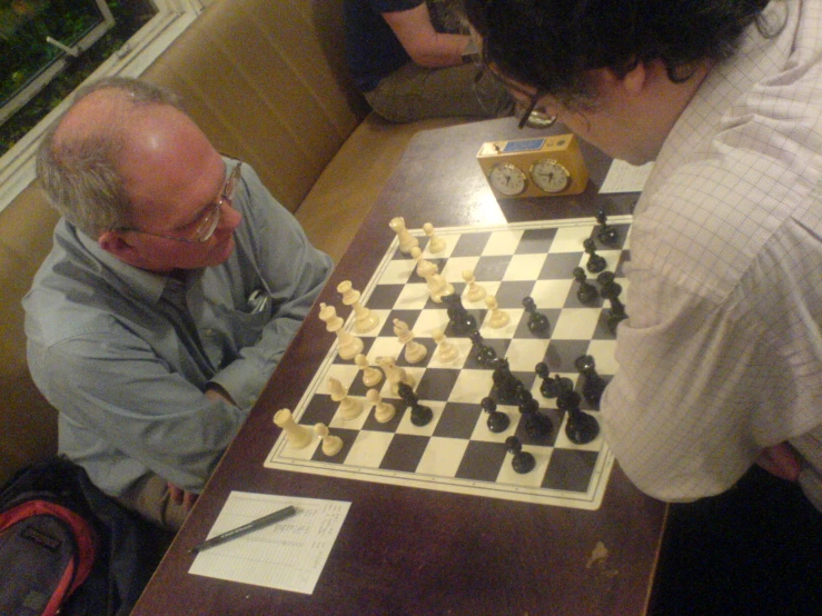 two men sitting at a table playing chess