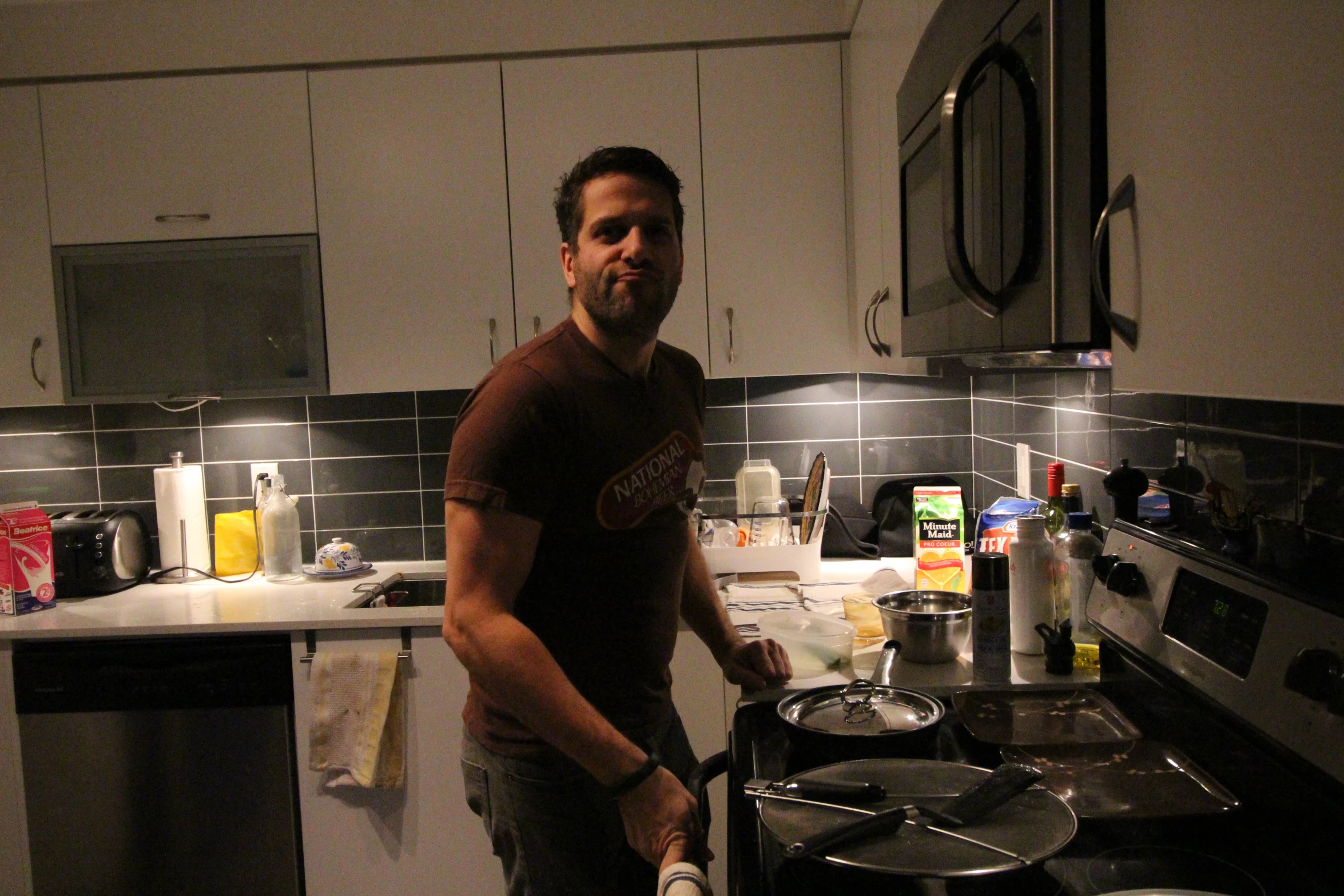 a man with a beard standing near a stove