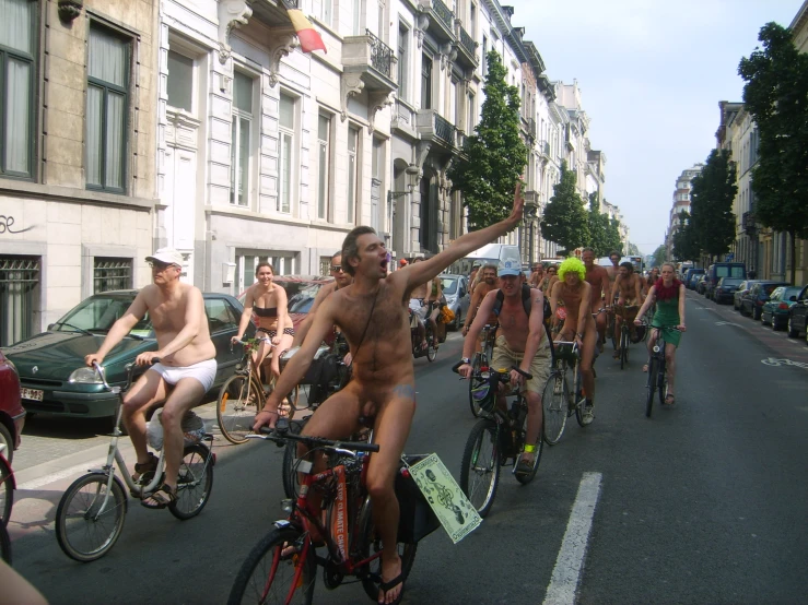 a group of  men riding bikes down a street