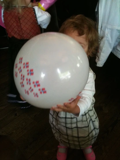 a young child playing with a white balloon
